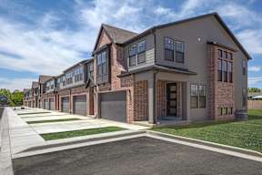 A row of houses with garages and driveways.