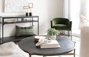 A black round table with a white phone and a book on it.