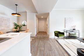 A modern kitchen with a green chair and a white counter.