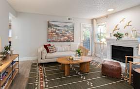 A living room with a white couch, a coffee table, and a painting on the wall.