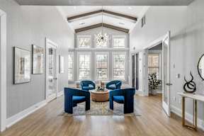 A residential lounge and lobby area with chairs and large windows at Bardin Greene apartments for rent in Arlington, Texas.