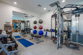 A gym with a variety of equipment including a squat rack, bench, and weights.