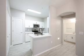 A kitchen with white cabinets and a white countertop.
