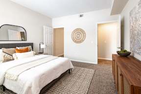 A bedroom with a large bed and a wooden cabinet.