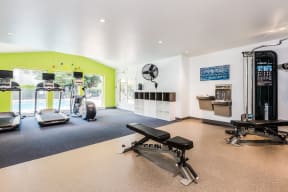 a gym with exercise equipment and a large window
