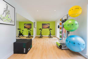 a home gym with green walls and hardwood flooring