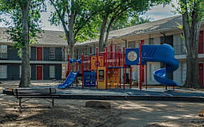 A playground with a blue slide and a red and yellow play structure.