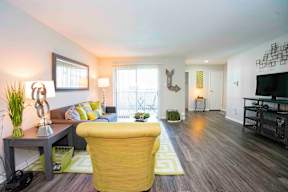 A living room with a yellow chair and a grey table