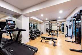 A gym with a treadmill, weights, and exercise equipment.