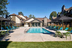 a swimming pool with blue chaise lounge chairs and umbrellas