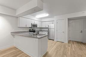 A kitchen with a granite countertop and white cabinets.