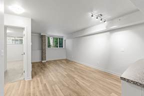 A room with wooden flooring and white walls.