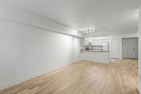 A room with wooden flooring and white walls.