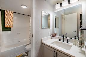 A white bathroom with a white tub and sink.