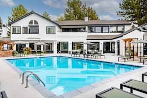 A large white house with a pool in the backyard.
