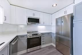 A modern kitchen with stainless steel appliances and white cabinets.