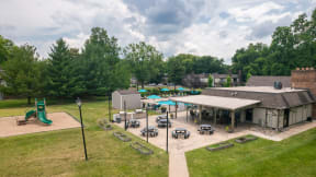 an aerial view of a playground and a pavilion with picnic tables