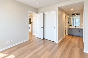 A room with a white door and wooden flooring.