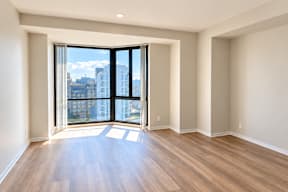 A room with a large window and wooden flooring.