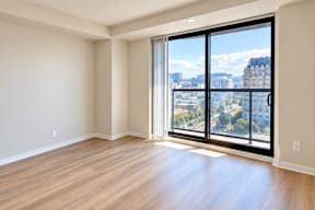 A large, empty room with a view of the city through the windows.