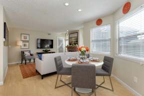 A dining room with a table set for four.