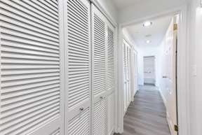 A long hallway with white walls and a white floor.