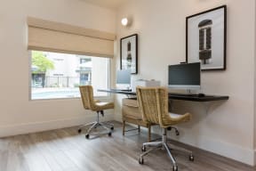 a home office with two chairs and a desk with a computer