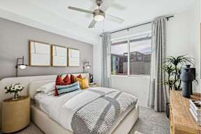 A bedroom with a large bed and a ceiling fan.