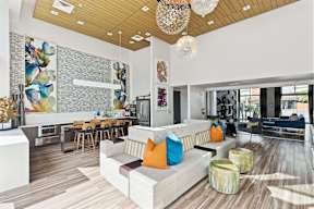 A modern living room with a white couch and a wooden floor.