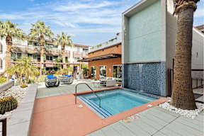 A pool surrounded by palm trees and a building.