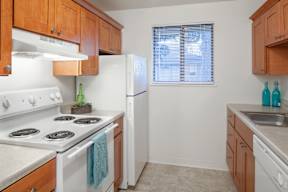 A kitchen with white appliances and wooden cabinets.