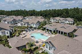 A bird's eye view of a residential area with houses and a swimming pool.