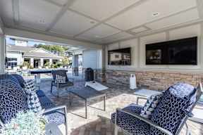 A patio with a black and white patterned chair and a grey table.