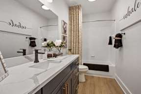 A white sink with a black faucet and a white counter top.