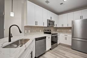 A modern kitchen with stainless steel appliances and white cabinets.