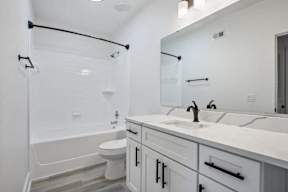 A white bathroom with a toilet, sink, and bathtub.