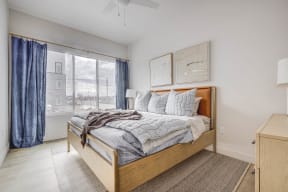 a bedroom with a bed and a large window