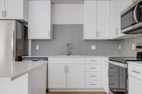 a kitchen with white cabinets and a counter top