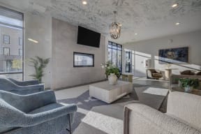 a lobby with couches and chairs and a television