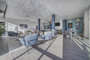 a living room with blue chairs and tables and a fireplace