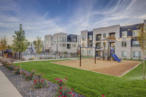 a playground in a park with apartments in the background