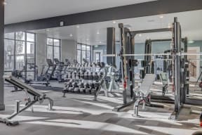 a gym with weights and cardio equipment and windows
