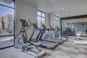 a row of treadmills and other exercise equipment in a gym