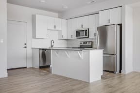 a kitchen with white cabinets and stainless steel appliances