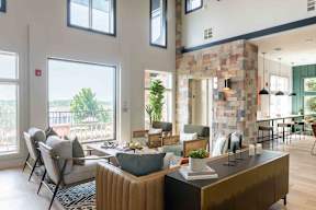 A modern living room with a stone wall and a large window overlooking a deck.