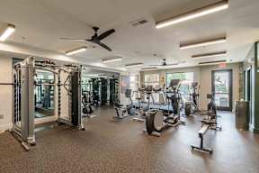 A spacious gym with a variety of equipment including treadmills, elliptical machines, and weight machines.