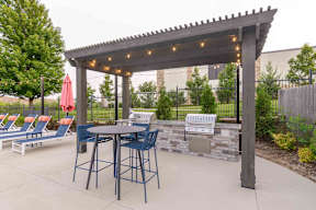 A patio with a table and chairs under a pergola.