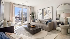 a living room with a couch and a table   and a balcony