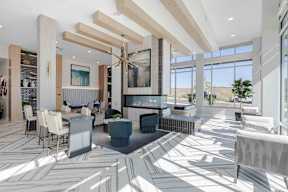 a rendering of a lobby with tables and chairs and a fireplace