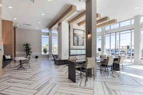 a large lobby with tables and chairs and large windows